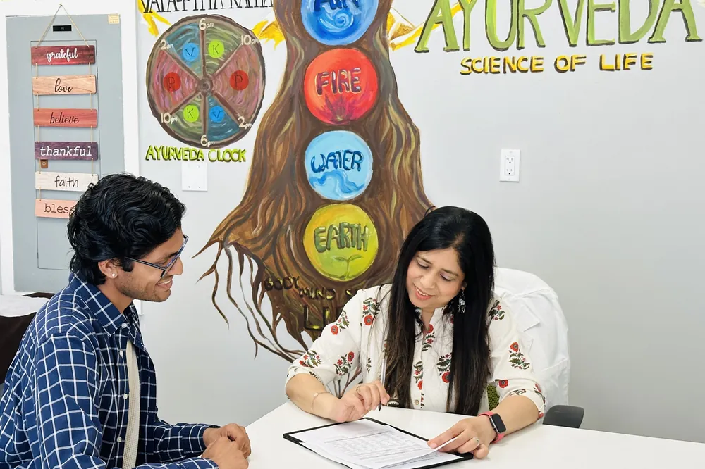 Preeti with a client at the San Ramon clinic, going through a written plan